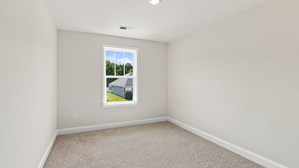 Bedroom with carpet and windows.