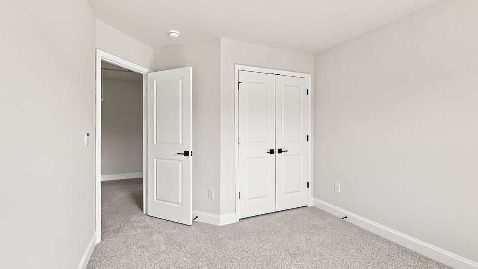 Bedroom with carpet and windows.