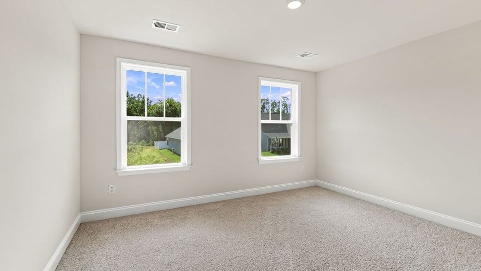 Bedroom with carpet and windows.