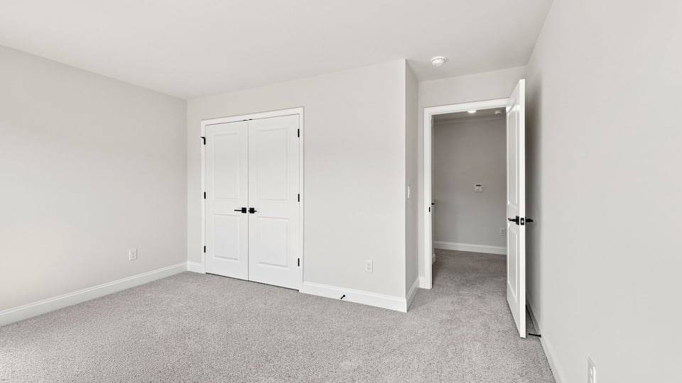 Bedroom with carpet and windows.