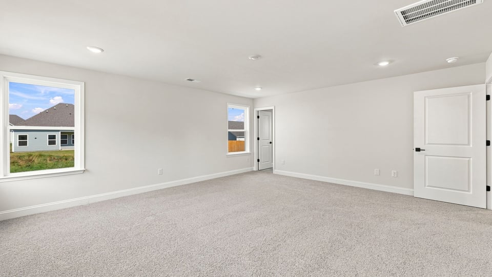 Bedroom with carpet and windows.