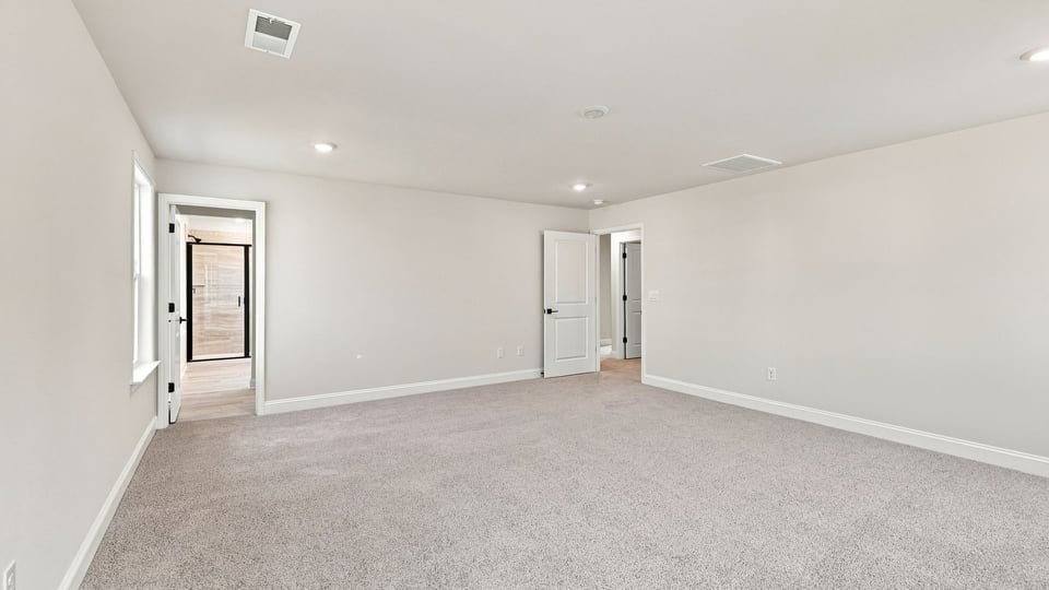Bedroom with carpet and windows.