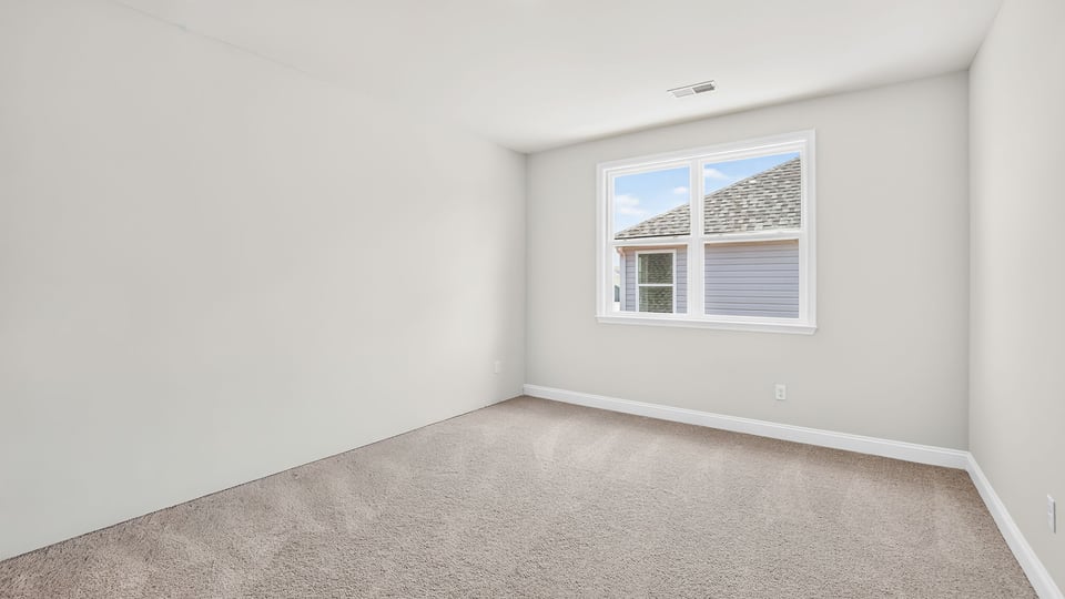 Bedroom with carpet and window.