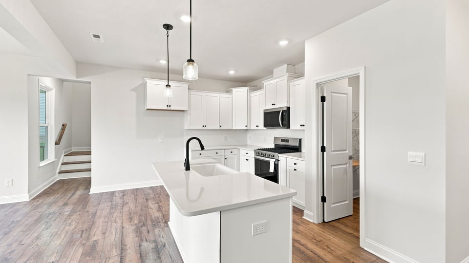 Kitchen and island with quartz countertops.