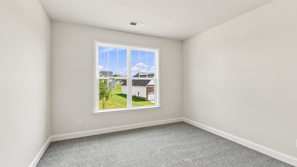 Bedroom with carpet and window.