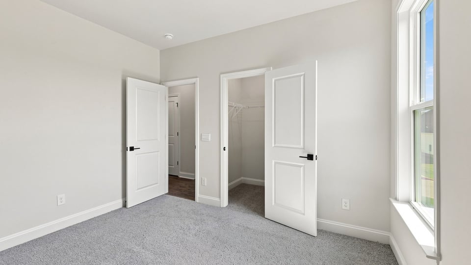 Bedroom with carpet and window.