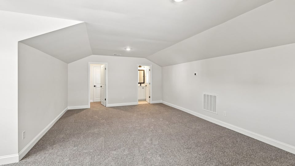 Loft area with carpet and window.
