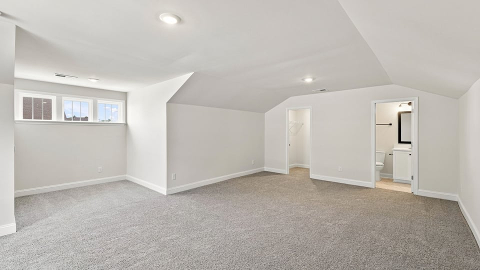 Loft area with carpet and window.