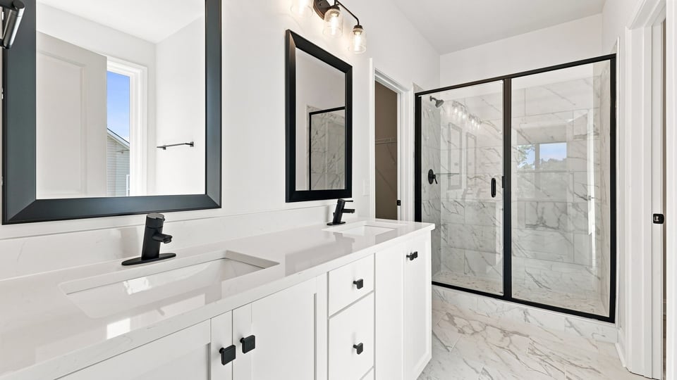 Bathroom with double vanity sink and walk in shower.