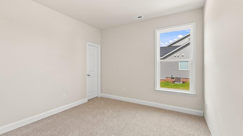 Bedroom with carpet and window.