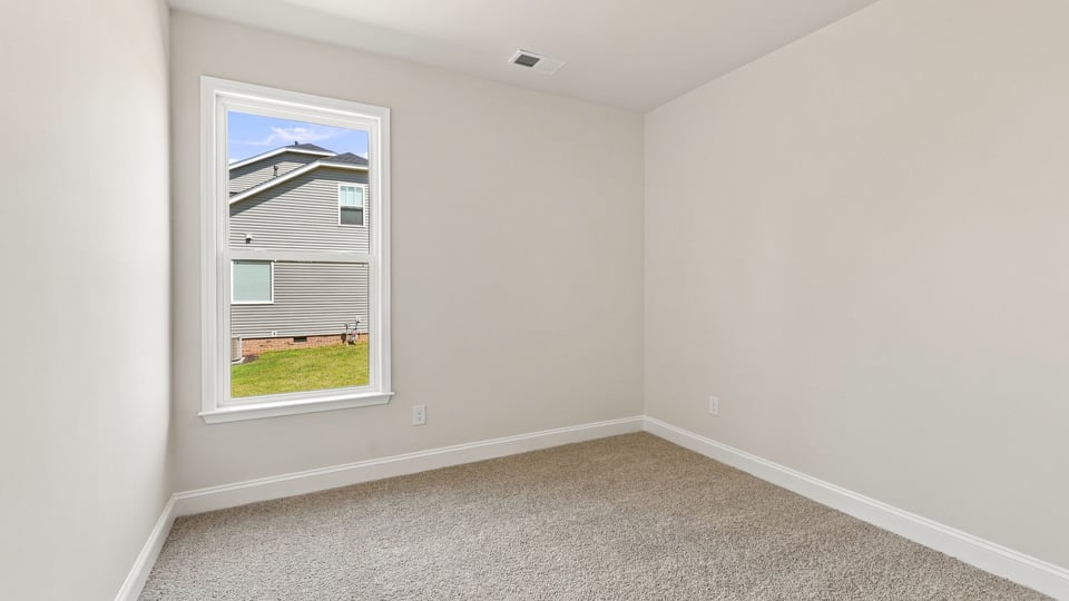 Bedroom with carpet and window.