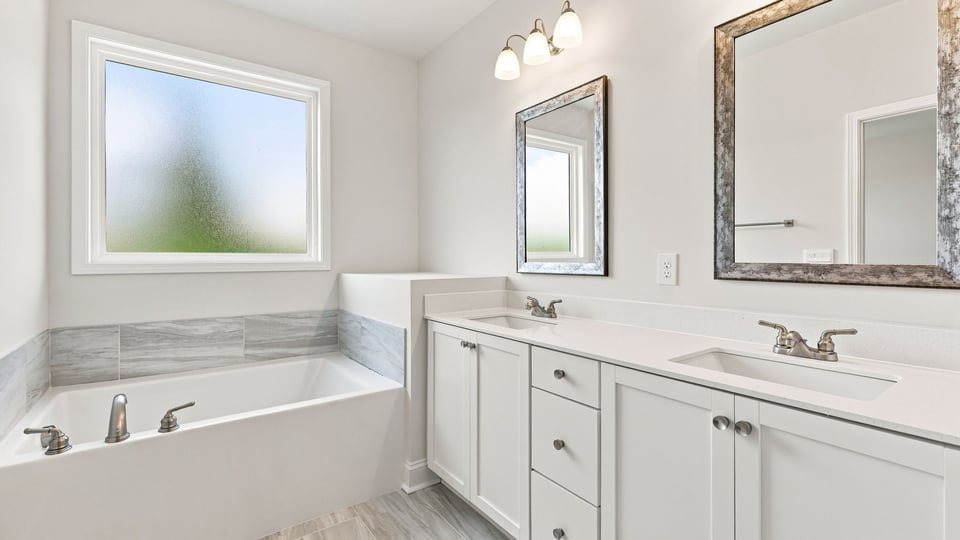 Bathroom with double vanity sink and bathtub.