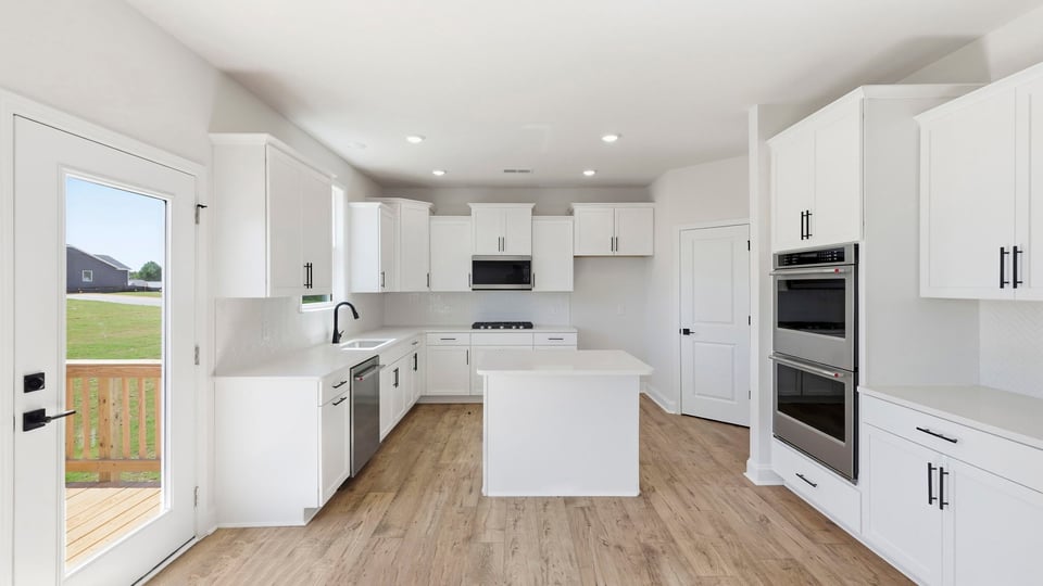 Kitchen and island with quartz countertops and stainless steel appliances.