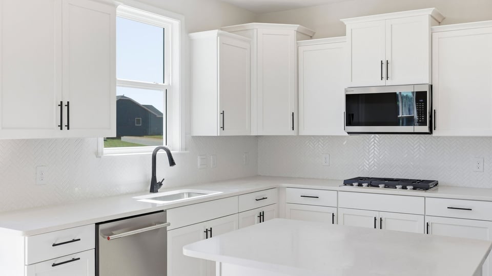 Kitchen and island with quartz countertops and stainless steel appliances.