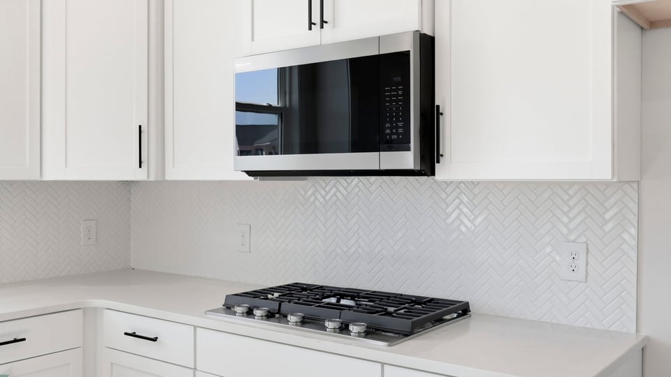 Kitchen and island with quartz countertops and stainless steel appliances.