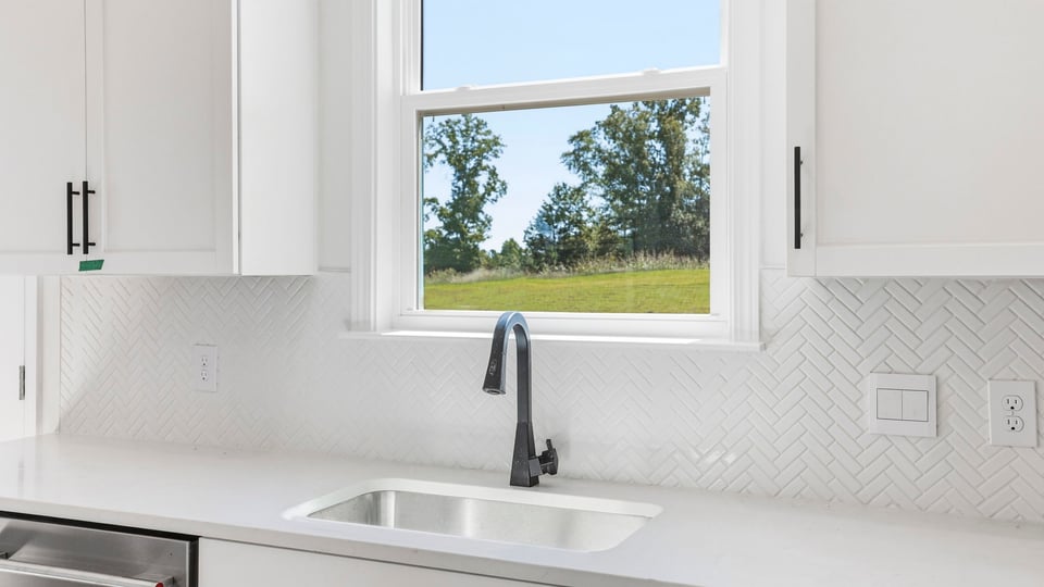 Kitchen and island with quartz countertops and stainless steel appliances.