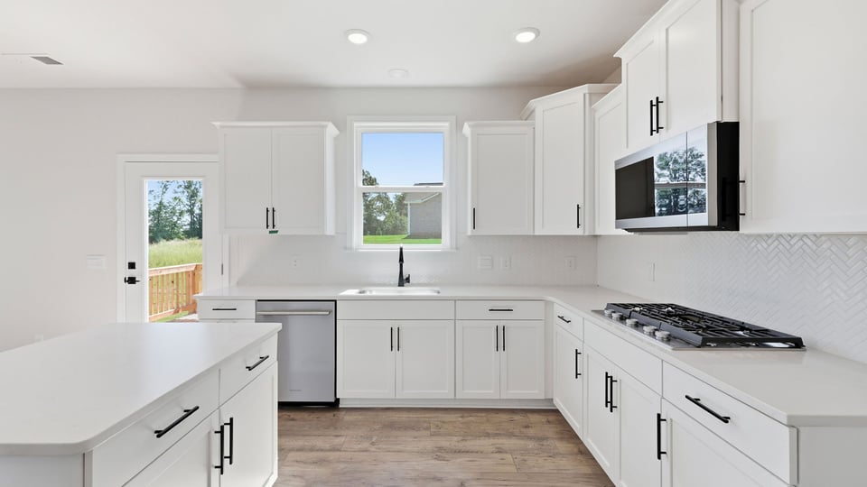 Kitchen and island with quartz countertops and stainless steel appliances.