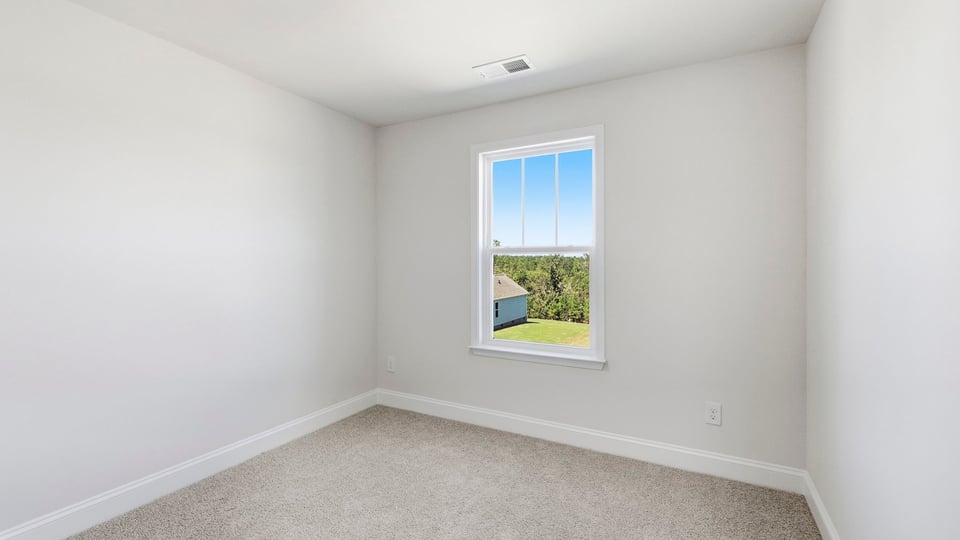 Bedroom with carpet and window.