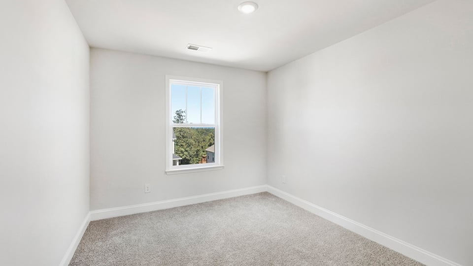 Bedroom with carpet and window.