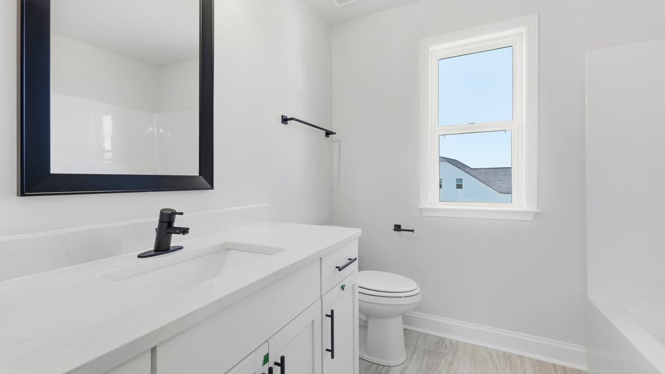 Bathroom with double vanity sink and window.
