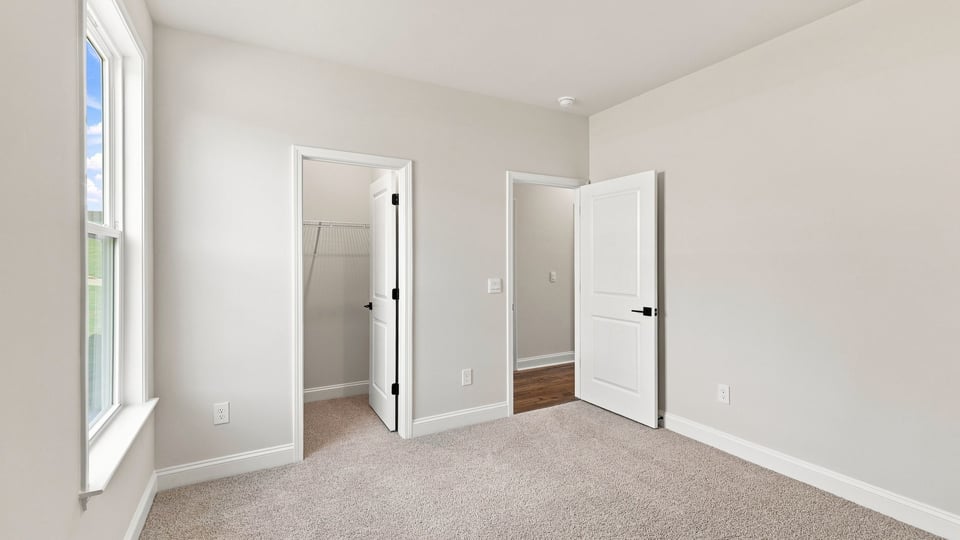 Bedroom with carpet and window.
