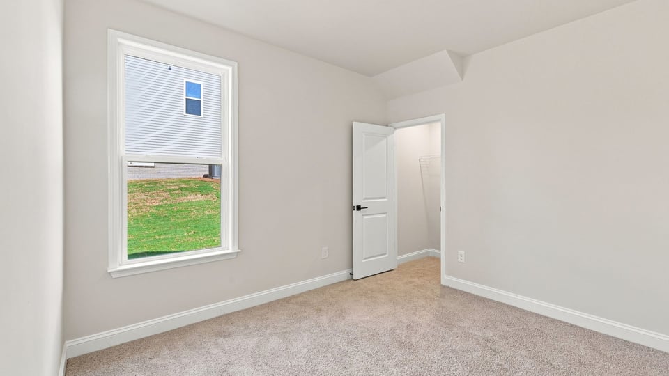Bedroom with carpet and window.
