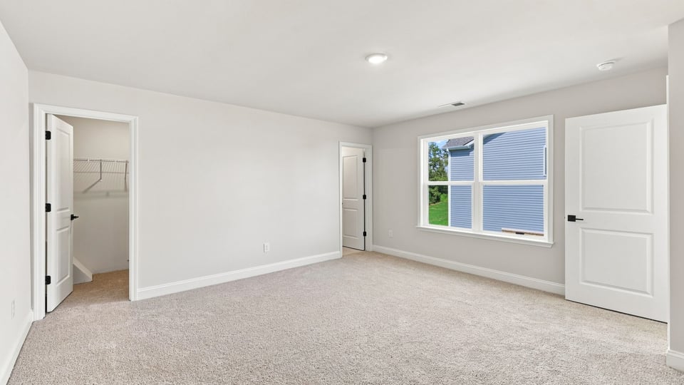 Bedroom with carpet and window.