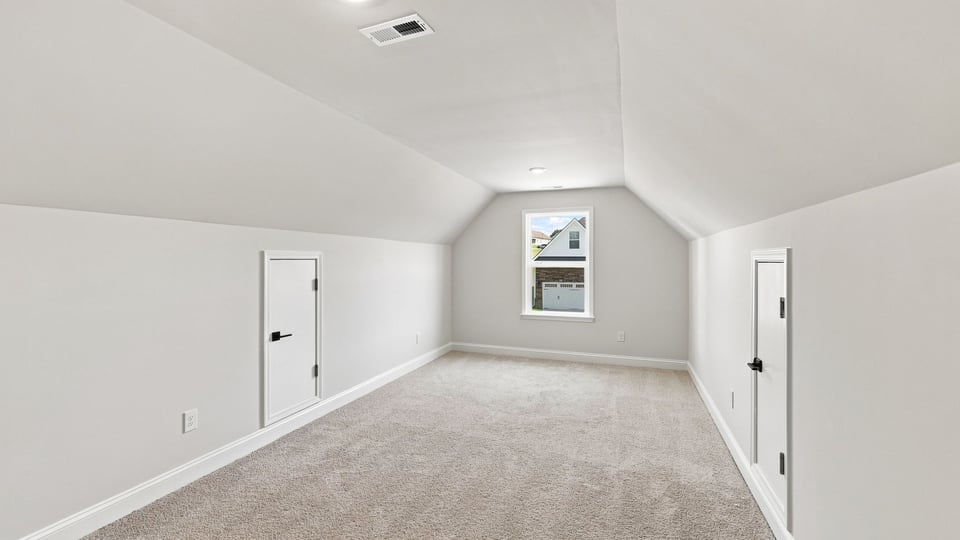 Loft area with carpet and window.