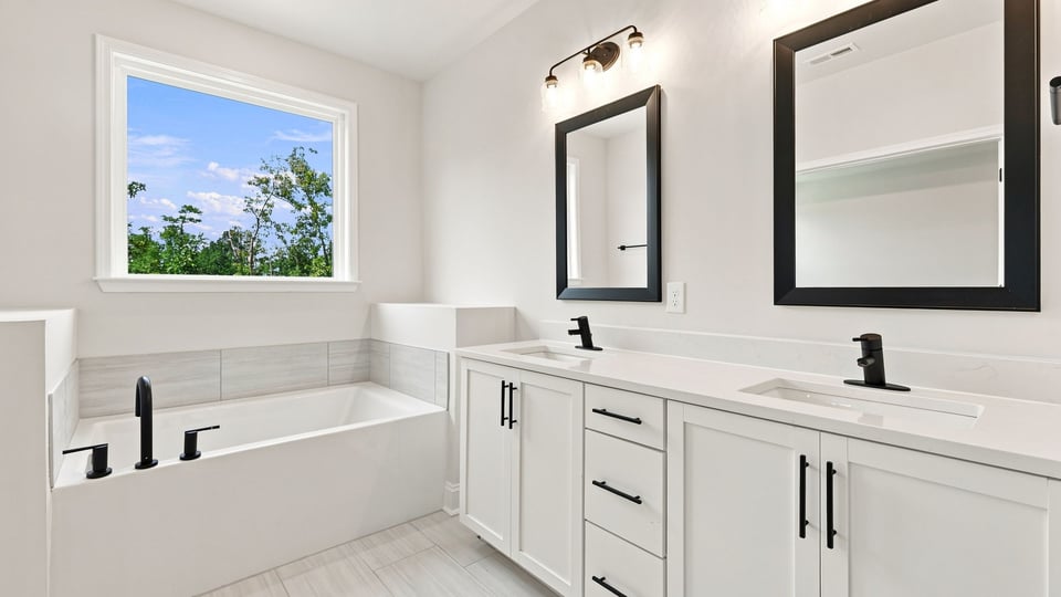 Bathroom with double vanity sink and bathtub.
