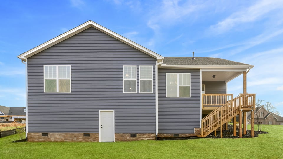 Back exterior with covered deck and large backyard.