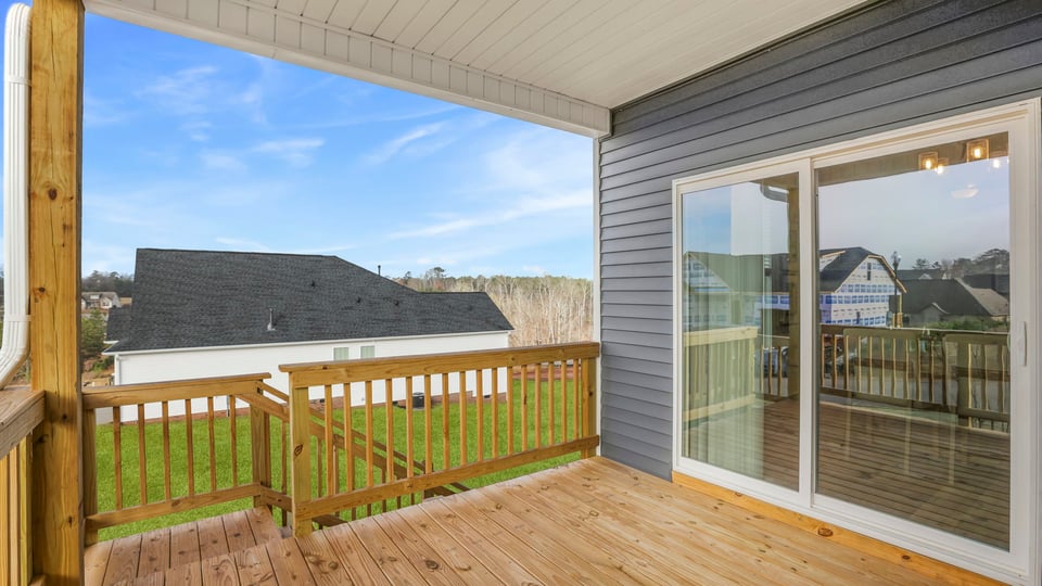 Back exterior with covered deck and large backyard.