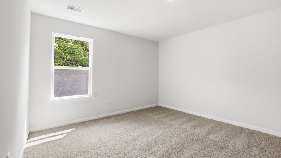 Bedroom with carpet and window.