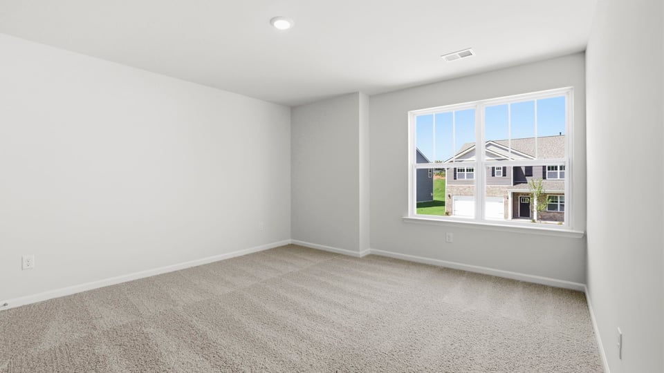 Bedroom with carpet and window.