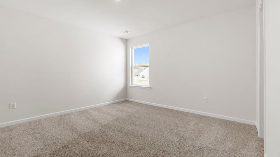 Bedroom with carpet and windows.