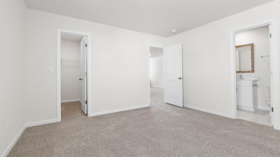 Bedroom with carpet and windows.