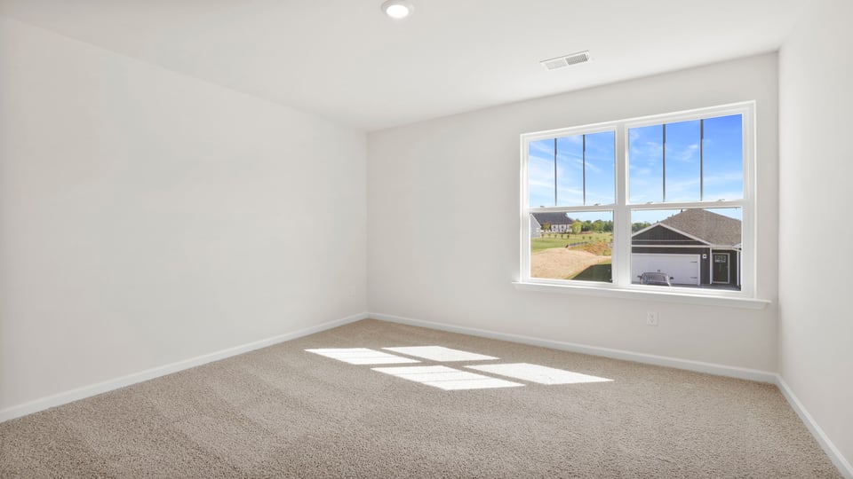 Bedroom with carpet and windows.