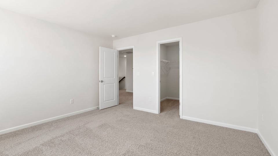 Bedroom with carpet and windows.