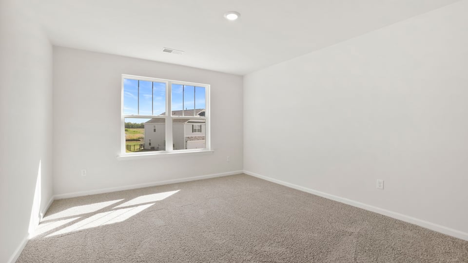 Bedroom with carpet and windows.