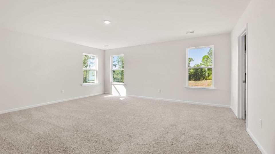 Bedroom with carpet and windows.