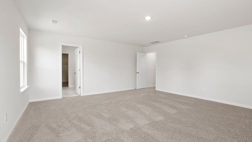 Bedroom with carpet and windows.