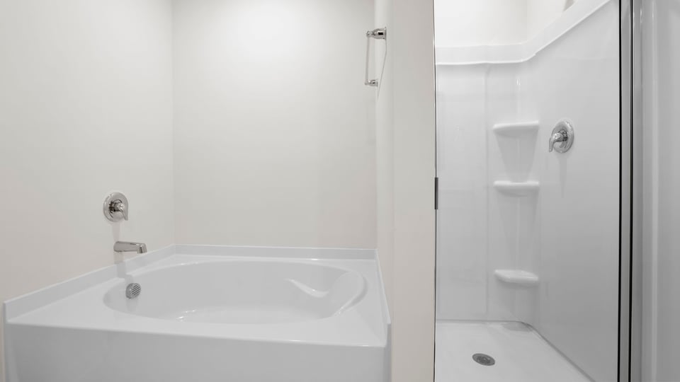 Bathroom with tub and walk in shower.