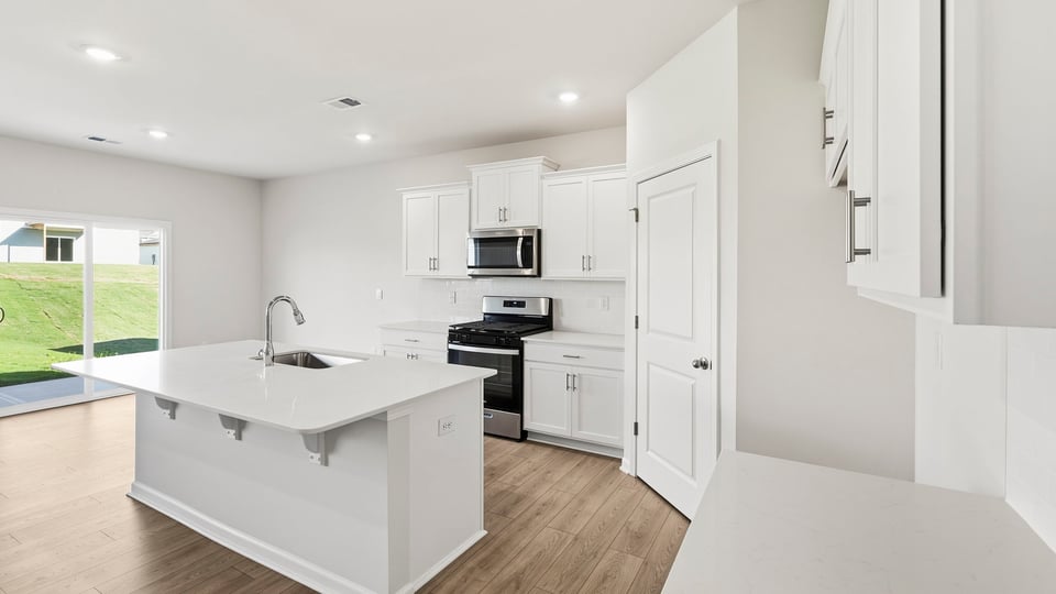 Kitchen and island with quartz countertops.