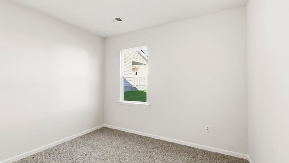 Bedroom with carpet and window.