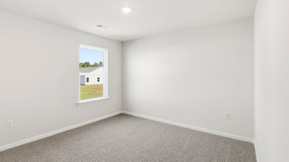 Bedroom with carpet and window.