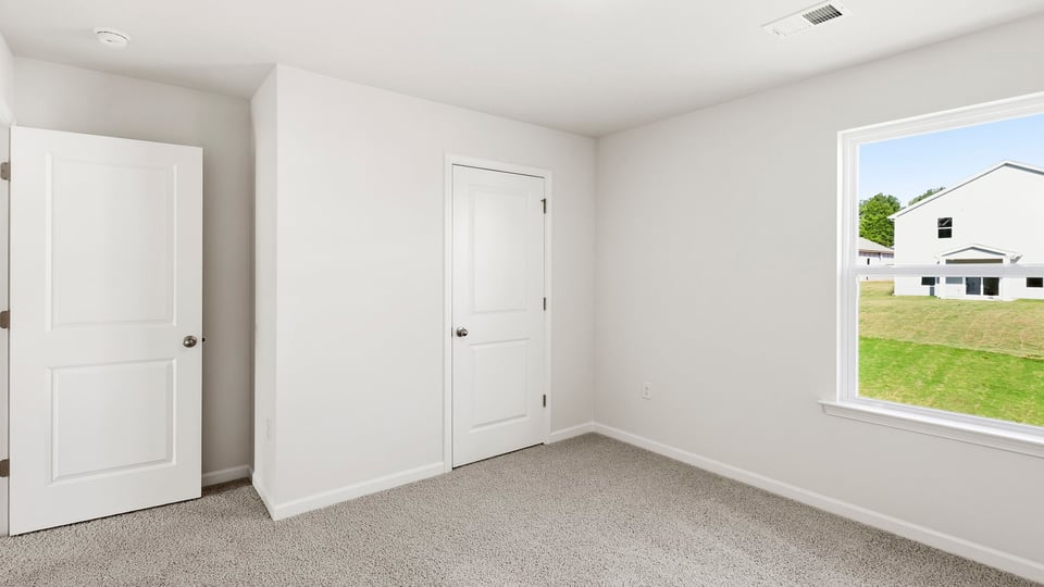 Bedroom with carpet and window.