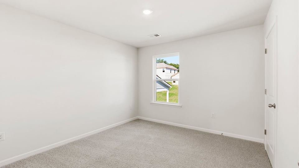 Bedroom with carpet and window.