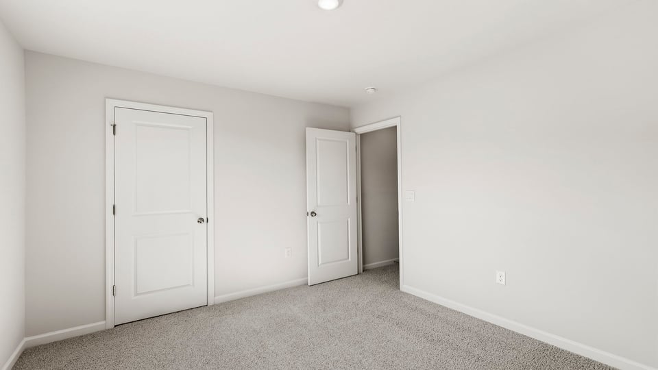 Bedroom with carpet and window.