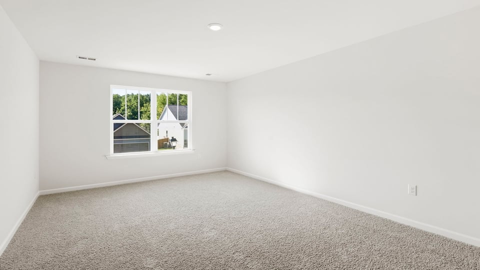 Bedroom with carpet and window.