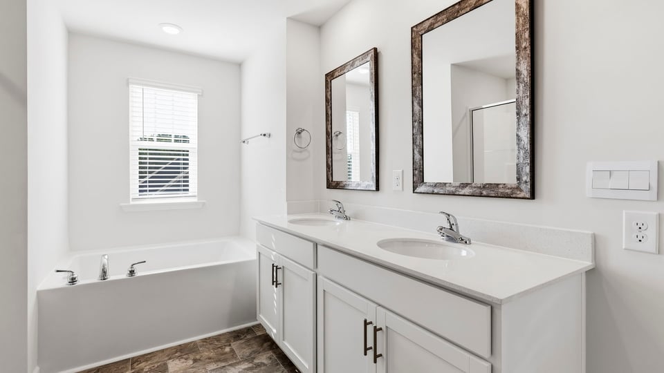 Bathroom with double vanity sink and bathtub.