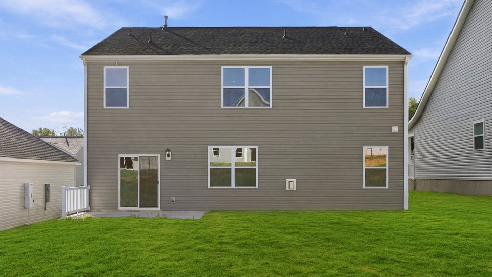 Back exterior of home with large backyard.